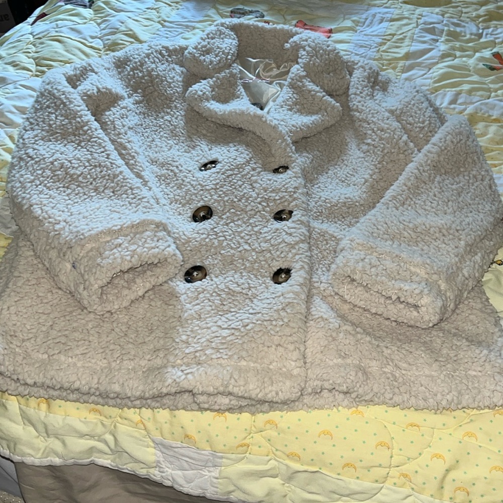 New Coat no tags. Fluffy soft three button up. Cream in color. Size S
